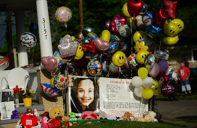 An FBI person missing sign stands in front of the family house of Gina DeJesus, one of the three women which were held captive for a decade, as it is decorated by well wishers May 7, 2013 in Cleveland. (AFP Photo / Emmanuel Dunand)