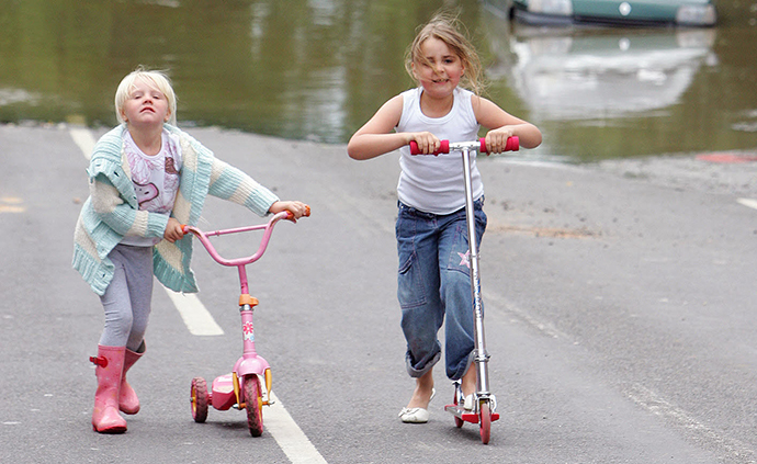 Children play on scooters in Treeton near Sheffield, England. (AFP Photo / Paul Ellis)