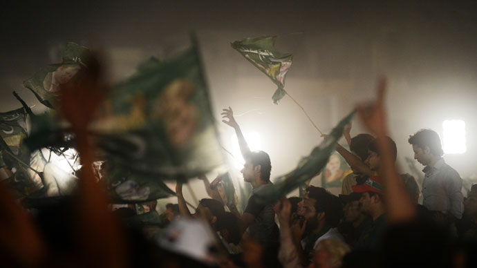 Supporters of former Pakistani Prime Minister Nawaz Sharif wave flags and cheer during his campaign closing rally in Lahore on May 9, 2013.(AFP Photo / Roberto Schmidt)