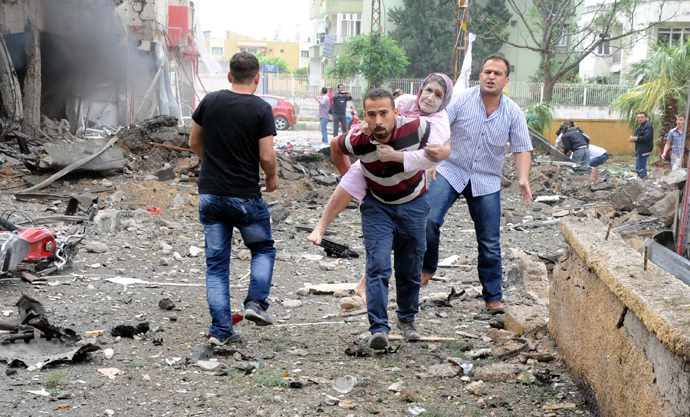 Residents evacuate a wounded woman to hospital after car bombs exploded on May 11, 2013 near the town hall in Reyhanli (AFP Photo / Ihlas News Agency)