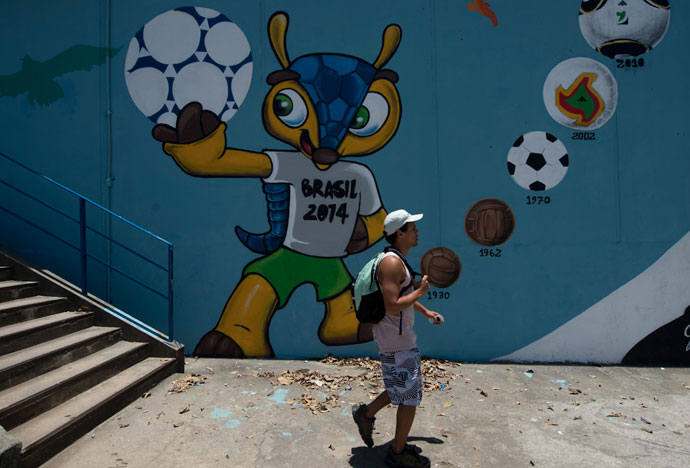 A man walks next to a mural depicting "Fuleco", the mascot of the Brazil 2014 FIFA World Cup.(AFP Photo / Christophe Simon)