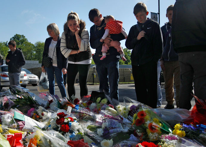 People view flowers left outside an army barracks near the scene of a killing in Woolwich, southeast London May 23, 2013.(Reuters / Luke MacGregor)