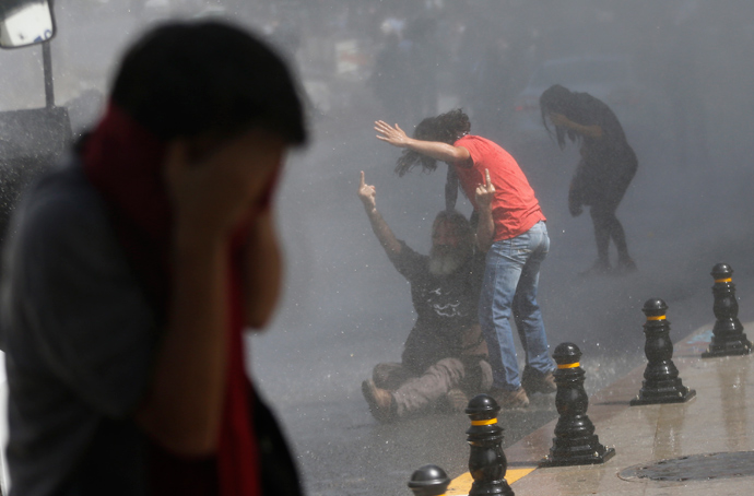 A demonstrator reacts as riot police use a water cannon and tear gas to disperse the crowd during a protest against the destruction of trees in a park brought about by a pedestrian project, in Taksim Square in central Istanbul May 31, 2013 (Reuters / Murad Sezer)