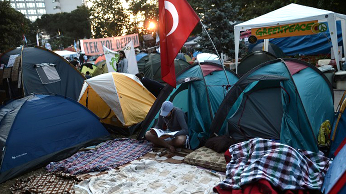 A demonstrator reads a magazine, amongst tents in Gazi park next to Taksim square in Istanbul early on June 8, 2013. (AFP Photo / Aris Messinis)