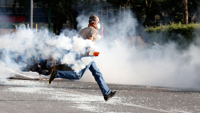A demonstrator runs as he throws a tear gas canister back at riot police during a protest against Turkey's Prime Minister Tayyip Erdogan and his ruling AK Party in central Ankara June 2, 2013 (Reuters / Umit Bektas)