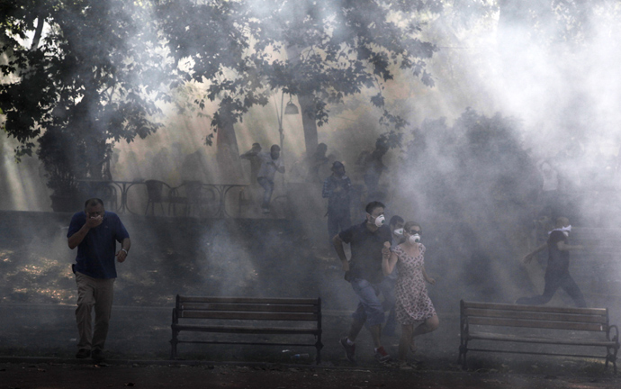 Protestors run away from tear gas at the Taksim Gezi park in Istanbul after clashes with riot police, on June 1, 2013, during a demonstration against the demolition of the park (AFP Photo / Gurcan Ozturk)