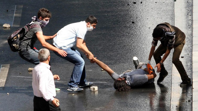 An injured demonstrator is helped during clashes between riot police and demonstrators in Ankara on June 1, 2013. (AFP Photo / Adem Altan)