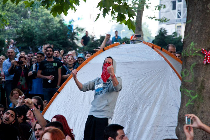 Demonstrators cheer as they stand near a tent on Taksim square in Istanbul on June 7, 2013. (AFP Photo / Gurcan Ozturk)