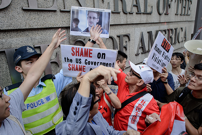 Protesters shout slogans as they hold up a picture of former US spy Edward Snowden in front of the US consulate in Hong Kong on June 13, 2013. (AFP Photo / Philippe Lopez)