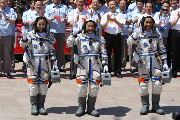 Chinese astronauts (L-R) Wang Yaping, Zhang Xiaoguang and mission commander Nie Haisheng wave to onlookers as they prepare to board the Shenzhou-10 spacecraft in Jiuquan, northwest China's Gansu on June 11, 2013 (China out / AFP Photo) 