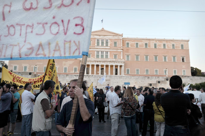 A Greek protestor holds a banner as he takes part in a demonstration in front of the parliament in Athens on May 31, 2013. (AFP Photo)