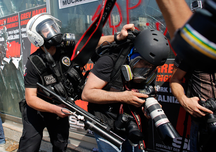 A Turkish riot policeman pushes a photographer during a protest at Taksim Square in Istanbul June 11, 2013 (Reuters / Murad Sezer)