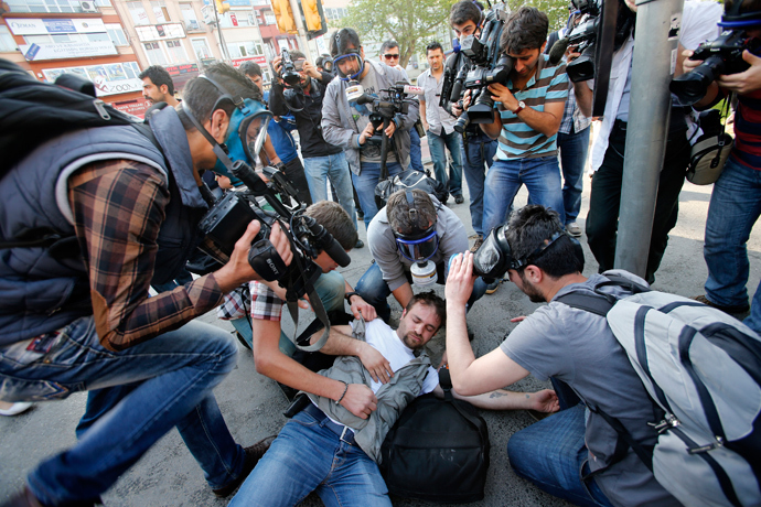 An injured journalist is filmed and helped by his colleagues during clashes between riot police and May Day protesters in central Istanbul (Reuters / Murad Sezer)