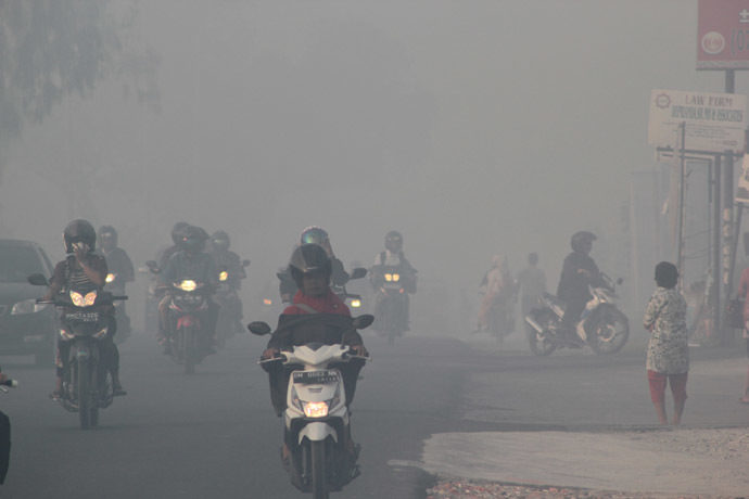 Indonesian motorists travel under a blanket of haze in Pekanbaru city, capital of Riau province on Sumatra island on June 20, 2013. (AFP Photo)