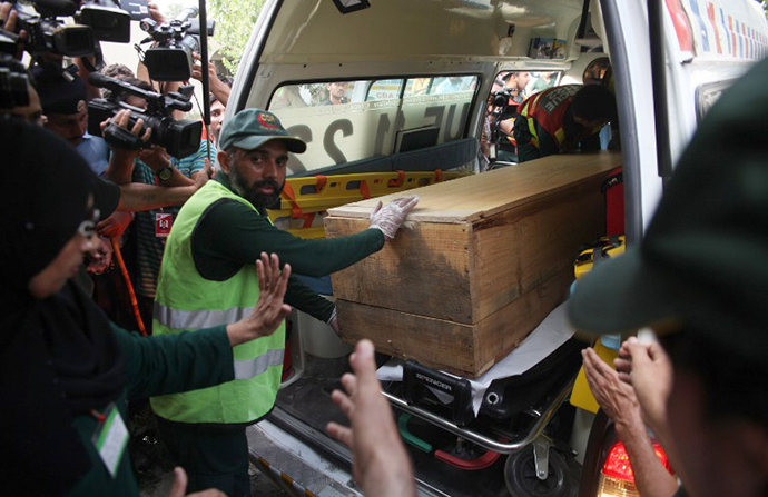 Pakistani rescuers shift a coffin of a foreign tourist from an ambulance to a hospital in Islamabad on June 23, 2013. (AFP Photo / Farooq Naeem)