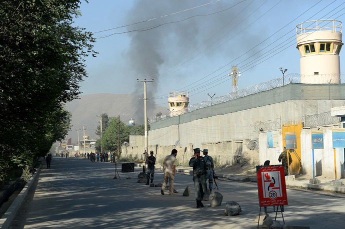 Afghan security forces stand guard as smoke rises from the entrance gate of the Presidential palace in Kabul on June 25, 2013. (AFP Photo)