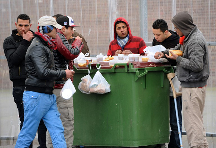 Illegal immigrants eat on February 28, 2013 meals distributed by the "La Belle Etoile" (Pretty Star) association in the port of the northwestern French city of Calais. (AFP Photo / Philippe Huguen)