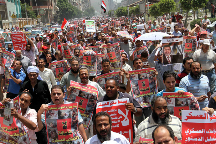 Thousands of supporters of ousted Egyptian president Mohamed Morsi march towards Cairo University during a protest in his support on July 12, 2013 as they hold posters reading "Down with the military rule" and "No to treason, no to military coup" along with pictures of fellow Muslim Brotherhood supporters who were killed in clashes with security forces earlier this week (AFP Photo)