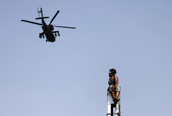 A military helicopter fly by, as protesters (unseen) call for the ouster of President Mohamed Morsi outside the presidential palace in Cairo, on July 2, 2013. (AFP Photo / Mahmud Khaled)