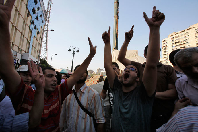 Supporters of the Muslim Brotherhood and ousted Egyptian President Mohamed Mursi shout slogans against the military and interior ministry as one gestures a 'four' during a protest in front of Al Istkama mosque at Giza Square, south of Cairo, August 19, 2013.(Reuters / Youssef Boudlal)