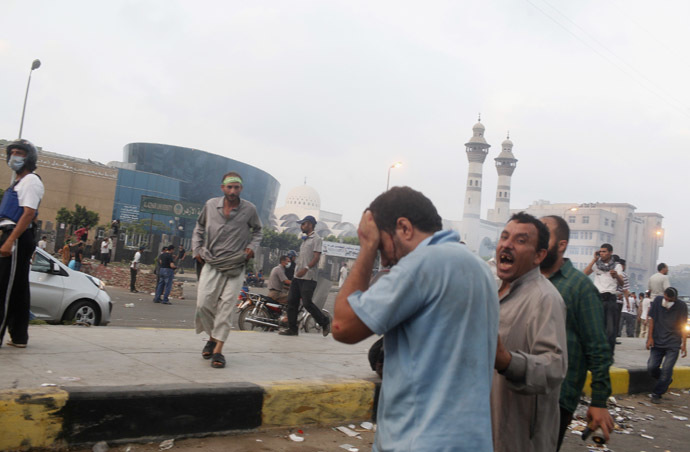 A supporter of deposed Egyptian President Mohamed Mursi whose eye was injured during clashes with police is escorted to safety in Nasr city area, east of Cairo, July 27, 2013. (Reuters/Asmaa Waguih)