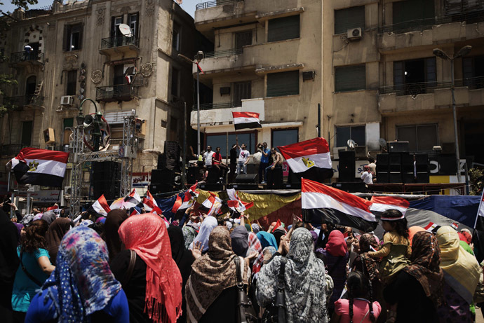 Egyptians cheer and wave their national flag as they gather in Cairo's landmark Tahrir square after a night of celebrations following the toppling of ousted Egyptian president Mohammed Morsi on July 4, 2013. (AFP Photo/Gianluigi Guercia)