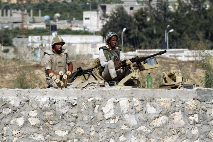 A picture taken from Rafah in the southern Gaza Strip on the border with Egypt, on July 8, 2013, shows Egyptian soldiers keeping watch on top of a tank on the Egyptian side of the border. (AFP Photo/Said Khatib)