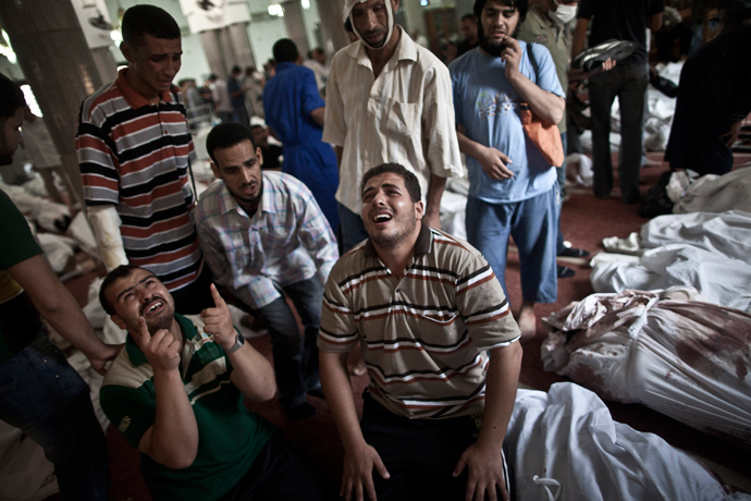 Egyptians mourn at a mosque in Cairo where lines of bodies wrapped in shrouds are laid out on August 15, 2013 (AFP Photo / Mahmoud Khaled)