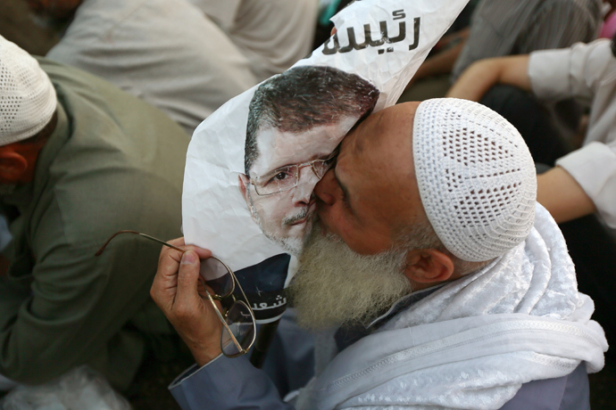 People celebrate at Tahrir Square with a portrait of Army chief Abdel Fattah al-Sisi after a broadcast confirming that the army will temporarily be taking over from the country's first democratically elected president Mohammed Morsi on July 3, 2013 in Cairo (AFP Photo / Khaled Desouki)