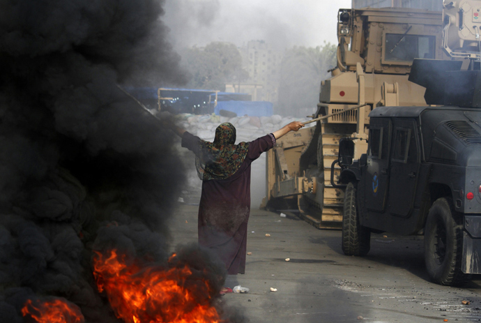 An Egyptian woman tries to stop a military bulldozer from going forward during clashes that broke out as Egyptian security forces moved in to disperse supporters of Egypt's deposed president Mohamed Morsi in a huge protest camp near Rabaa al-Adawiya mosque in eastern Cairo on August 14, 2013 (AFP Photo / Mohammed Abdel Moneim)