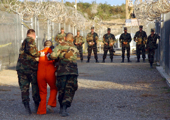 U.S. Army Military Police escort a detainee to his cell during in-processing to the temporary detention facility at Camp X-Ray in Naval Base Guantanamo Bay (Reuters / Stringer / Files)