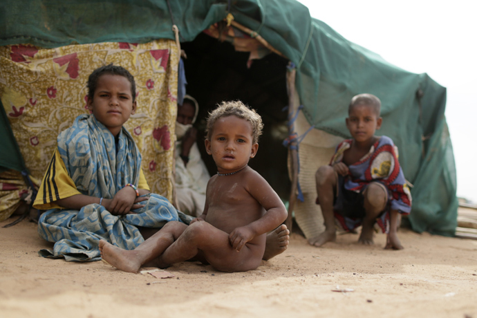 Malian refugees children sit in front of a ten at a refugee camp set in Menteao near the Malian border (AFP Photo / Kenzo Tribouillard) 