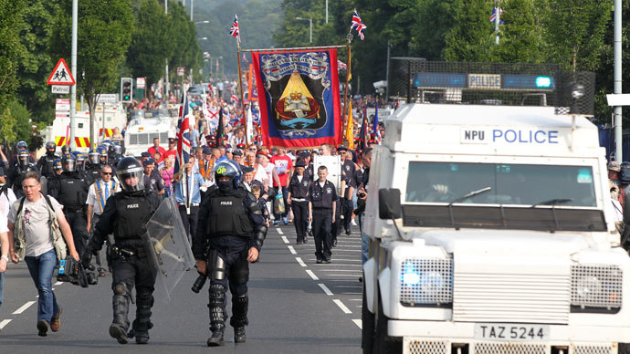 Police in riot gear escort protestant Orangemen marchers through the Catholic Ardoyne district of north Belfast, Northern Ireland, on July 12, 2013.(AFP Photo / Peter Muhly)