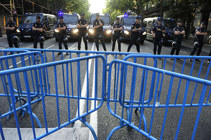 Policemen block the way to the PP (Popular Party)'s headquarters as people protest against Spanish Prime Minister Mariano Rajoy, in Madrid on July 18, 2013. (AFP Photo / Dominique Faget)