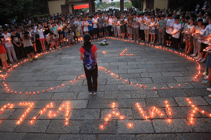 Students of the Jiangshan Middle School light candles to form a heart shape and initials (below), of the victims Yang Mengyuan and Wang Linjia of the Asiana Airlines crash, in Quzhou, Zhejiang province July 8, 2013 (Reuters / Stringer)