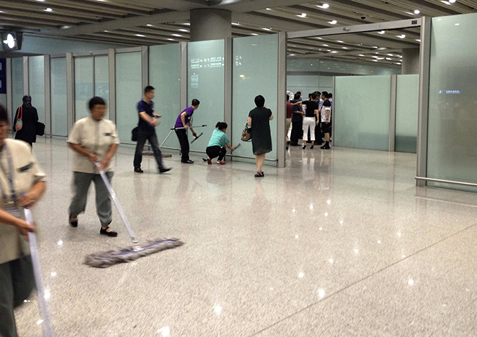 Airport staffs clean the floor and glasses at the arrival gate B where an explosion occurred at the Terminal 3 of Beijing Capital International Airport in Beijing, July 20, 2013. (Reuters / Jason Lee)