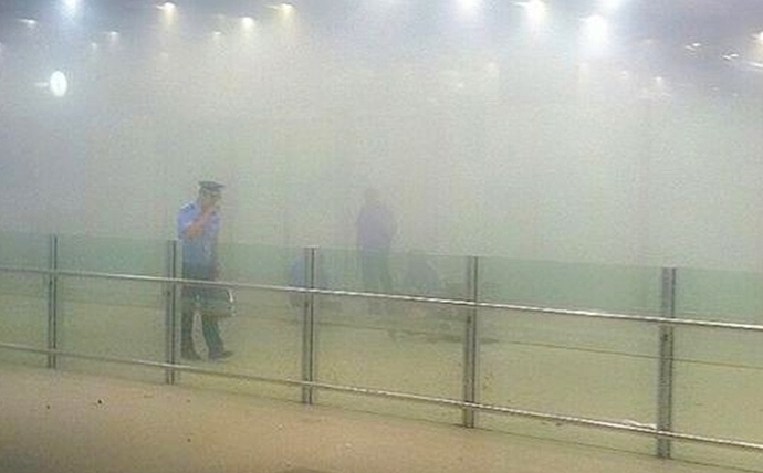 A policeman stands amid smoke at the arrival gate B after an explosion at the Terminal 3 of Beijing Capital International Airport in Beijing, July 20, 2013. (Reuters)