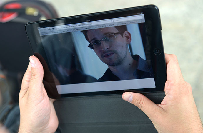 A journalist studies a photo of former CIA employee Edward Snowden, at Sheremetyevo Airport (RIA Novosti / Valeriy Melnikov)
