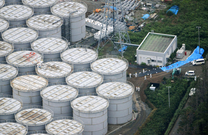An aerial view shows workers wearing protective suits and masks working atop contaminated water storage tanks at Tokyo Electric Power Co. (TEPCO)'s tsunami-crippled Fukushima Daiichi nuclear power plant in Fukushima, in this photo taken by Kyodo August 20, 2013. (Reuters/Kyodo)