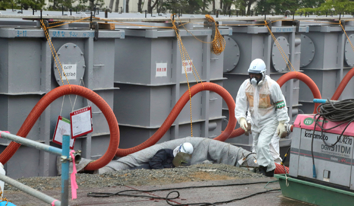 A worker walks in front of water tanks at Tokyo Electric Power Company's (TEPCO) tsunami-crippled Fukushima Daiichi nuclear power plant in Fukushima prefecture (Reuters / Noboru Hashimoto / Pool)