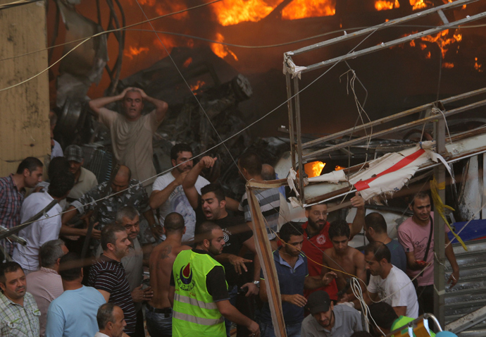 People react as the they gather around the site of an explosion in Beirut's southern suburbs, August 15, 2013 (Reuters / Mahmoud Kheir) 