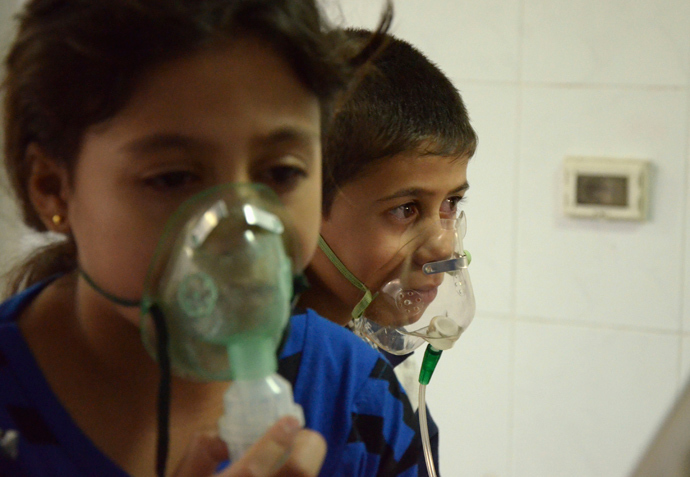 Children, affected by what activists say was a gas attack, breathe through oxygen masks in the Damascus suburb of Saqba, August 21, 2013 (Reuters / Bassam Khabieh)