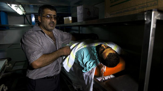 A man shows the body of a Palestinian man who was killed during clashes with Israeli security forces in Qalandia refugee camp, at a hospital in the West Bank city of Ramallah on August 26, 2013. (AFP Photo / Ahmad Gharabli)