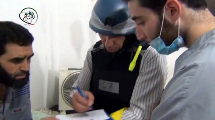 A UN inspector (C) listening to the testimony of a man in the Damascus suburb of Moadamiyet al-Sham. (AFP Photo)