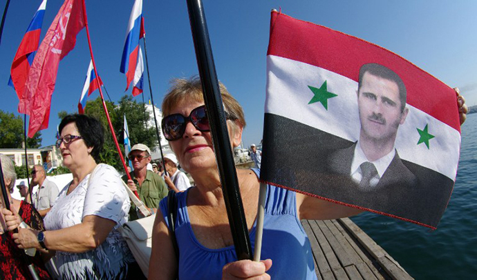 Ukrainian communists hold a Syrian flag bearing the picture of Syrian president Bashar al-Assad during a protest in his support and against the visit of the Standing NATO Mine Countermeasure Group SNMCMG2 to Sevastopol on August 29, 2013. (AFP Photo / Vasiliy Batanov)