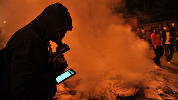 A protestor uses Facebook on mobile phone to give latestt news about the clashes near Taksim in Istanbul on June 3, 2013 during a demonstration against the demolition of the park. (AFP Photo / Ozan Kose)