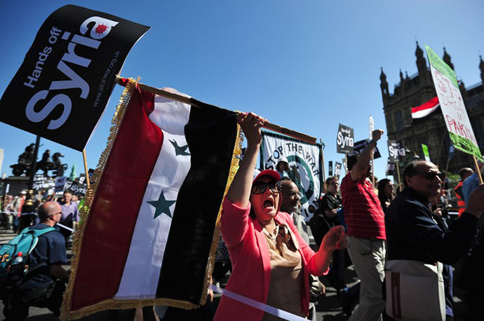 Protesters shout slogans and wave the Syrian flag as they demonstrate against military intervention in Syria in central London on August 31, 2013. (AFP Photo / Carl Court)
