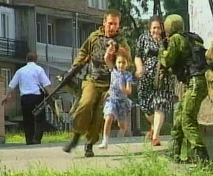 A television grab shows a soldier helping a girl away from the scene at a school in the town of Beslan in the province of North Ossetia (Reuters / Reuters TV)