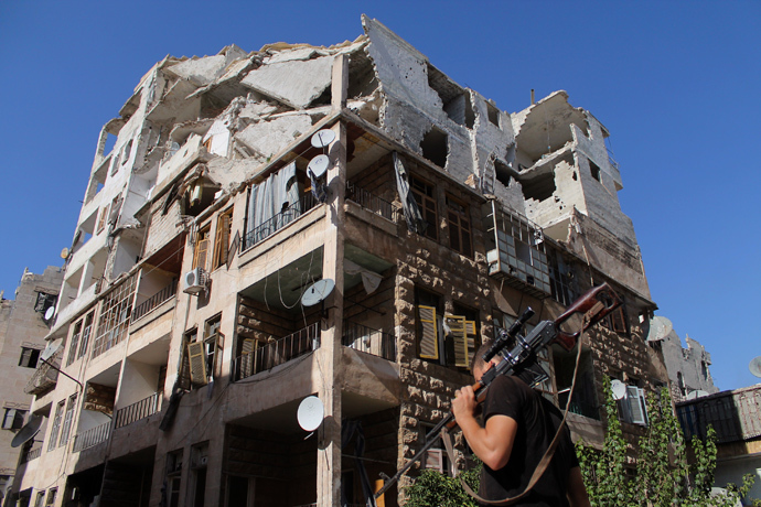 A Free Syrian Army fighter walks with his weapon in front of a damaged building in Aleppo's Al-Ezaa neighbourhood, September 1, 2013 (Reuters / Malek Alshemali)