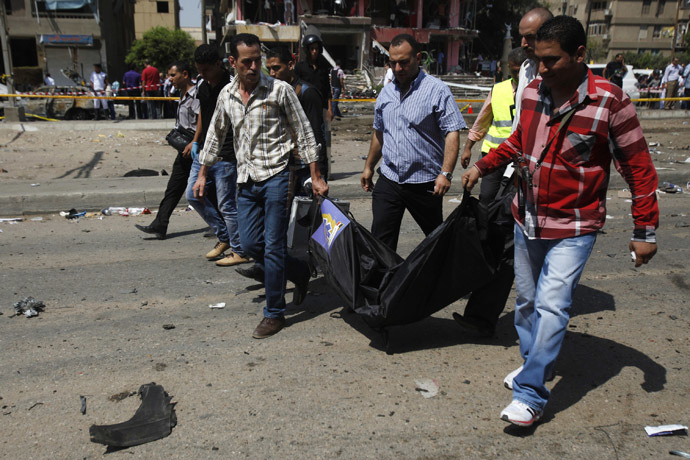 Medics and police carry recovered body parts from the site of a bomb attack and assassination attempt near the house of Egypt's Interior Minister Mohamed Ibrahim in the Nasr City district of Cairo September 5, 2013. (Reuters/Amr Abdallah Dalsh)
